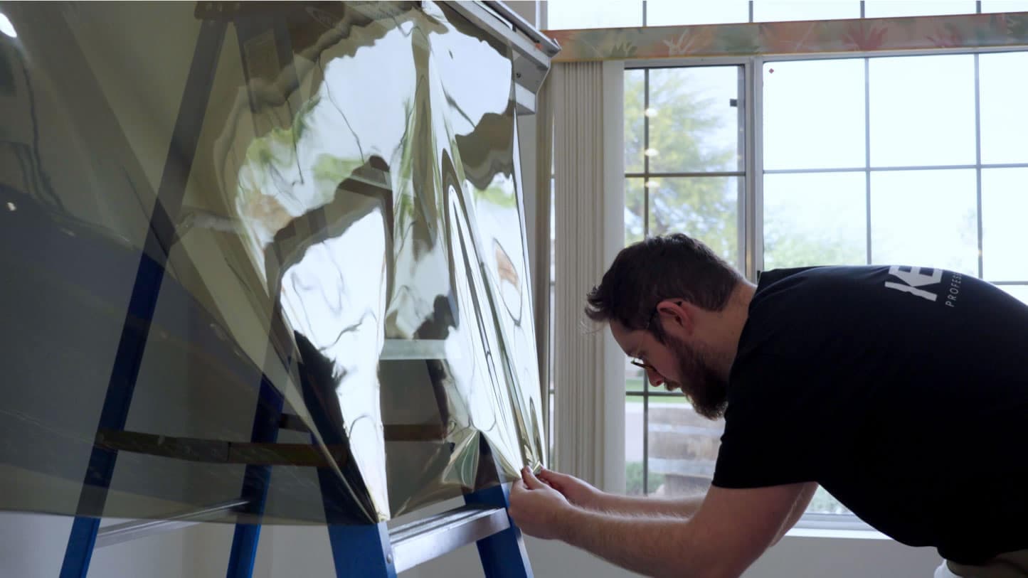 Pulling film down on glass